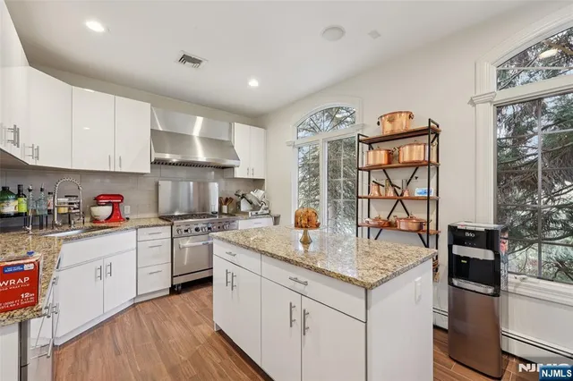 a kitchen with granite countertop a sink stove and cabinets