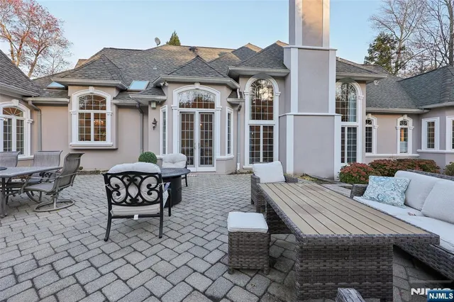 a view of a patio with couches table and chairs and wooden fence