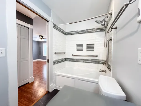 a bathroom with a tub shower and sink