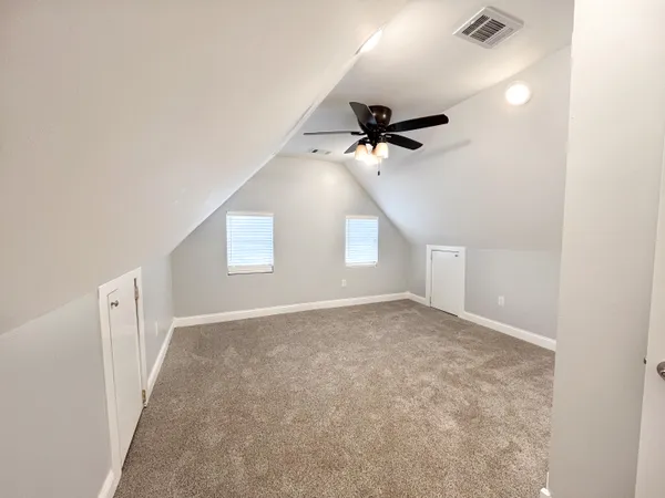 an empty room with a ceiling fan and a window