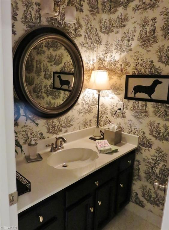 538 Lindley Road Greensboro, NC 27410 - Photo 7 of 29 The half bath has a tile floor, new vanity, mirror, brushed nickel plumbing and light fixtures and new commode.