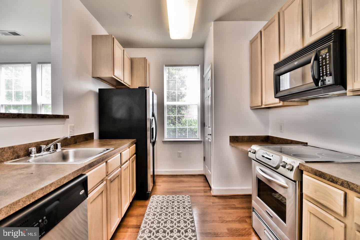 22687 Blue Elder Terrace, Unit 104 Brambleton, VA 20148 - Photo 6 of 23 a kitchen with a sink stove and microwave