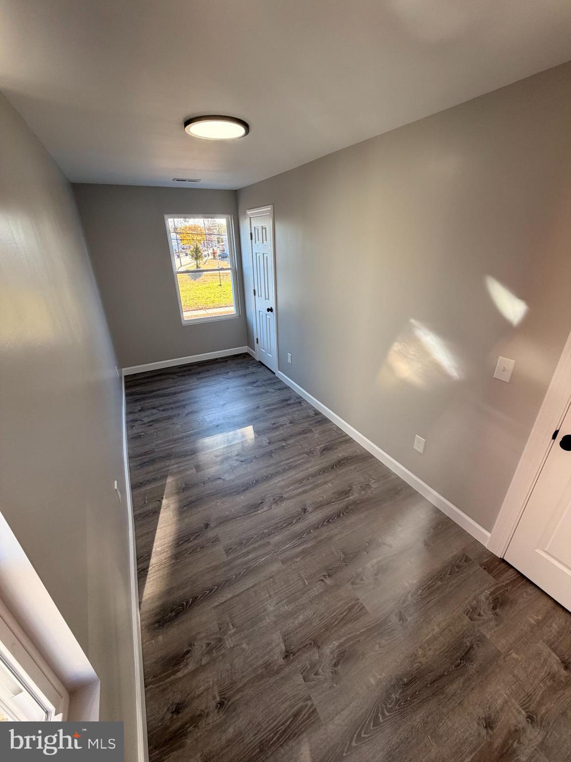 404 Sharp Street Millville, NJ 08332 - Photo 12 of 17 a view of empty room with window and wooden floor