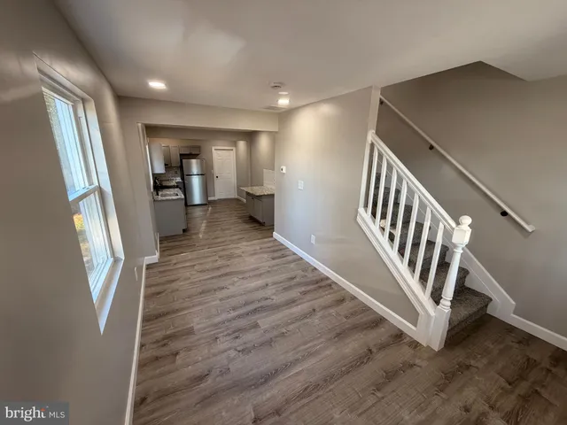 a view of a hallway with wooden floor and staircase