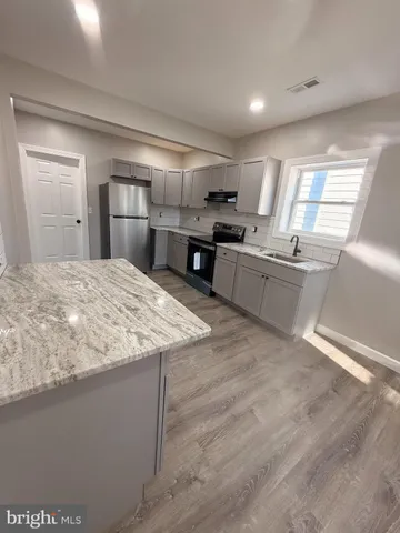 a kitchen with stainless steel appliances granite countertop a sink dishwasher stove and oven