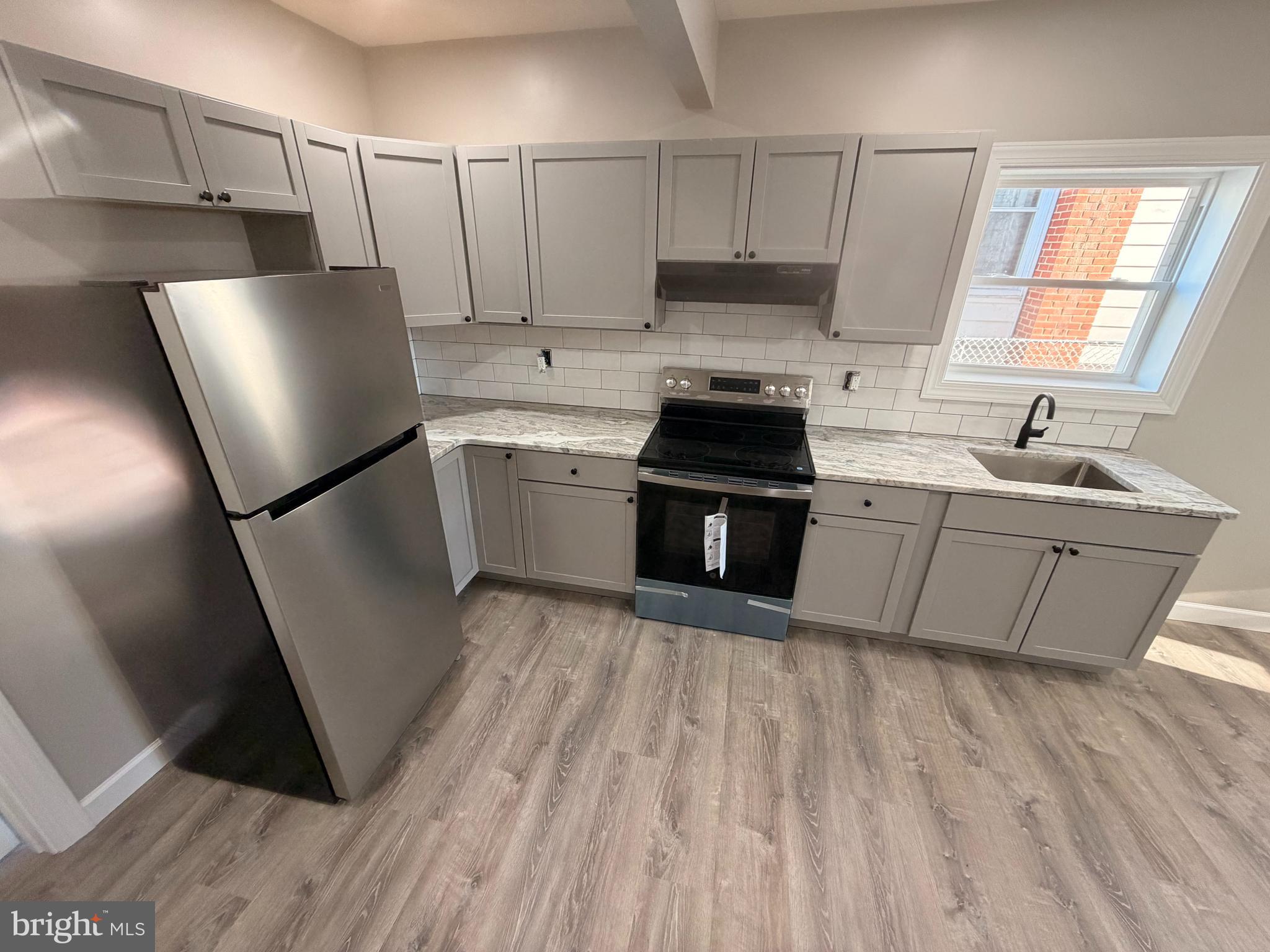 404 Sharp Street Millville, NJ 08332 - Photo 6 of 17 a kitchen with a sink a refrigerator and window