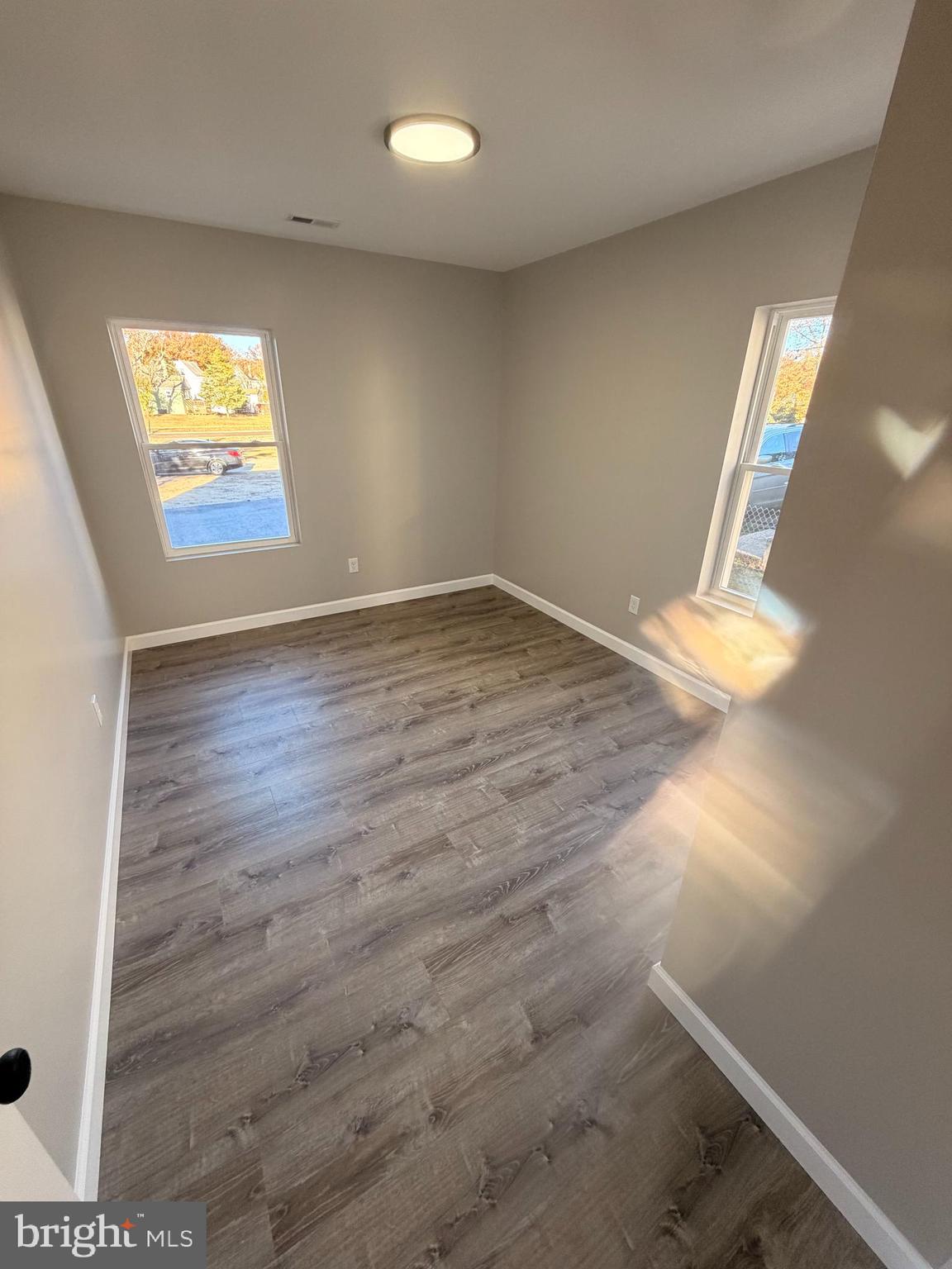404 Sharp Street Millville, NJ 08332 - Photo 8 of 17 an empty room with wooden floor and windows