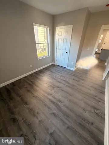an empty room with wooden floor and window