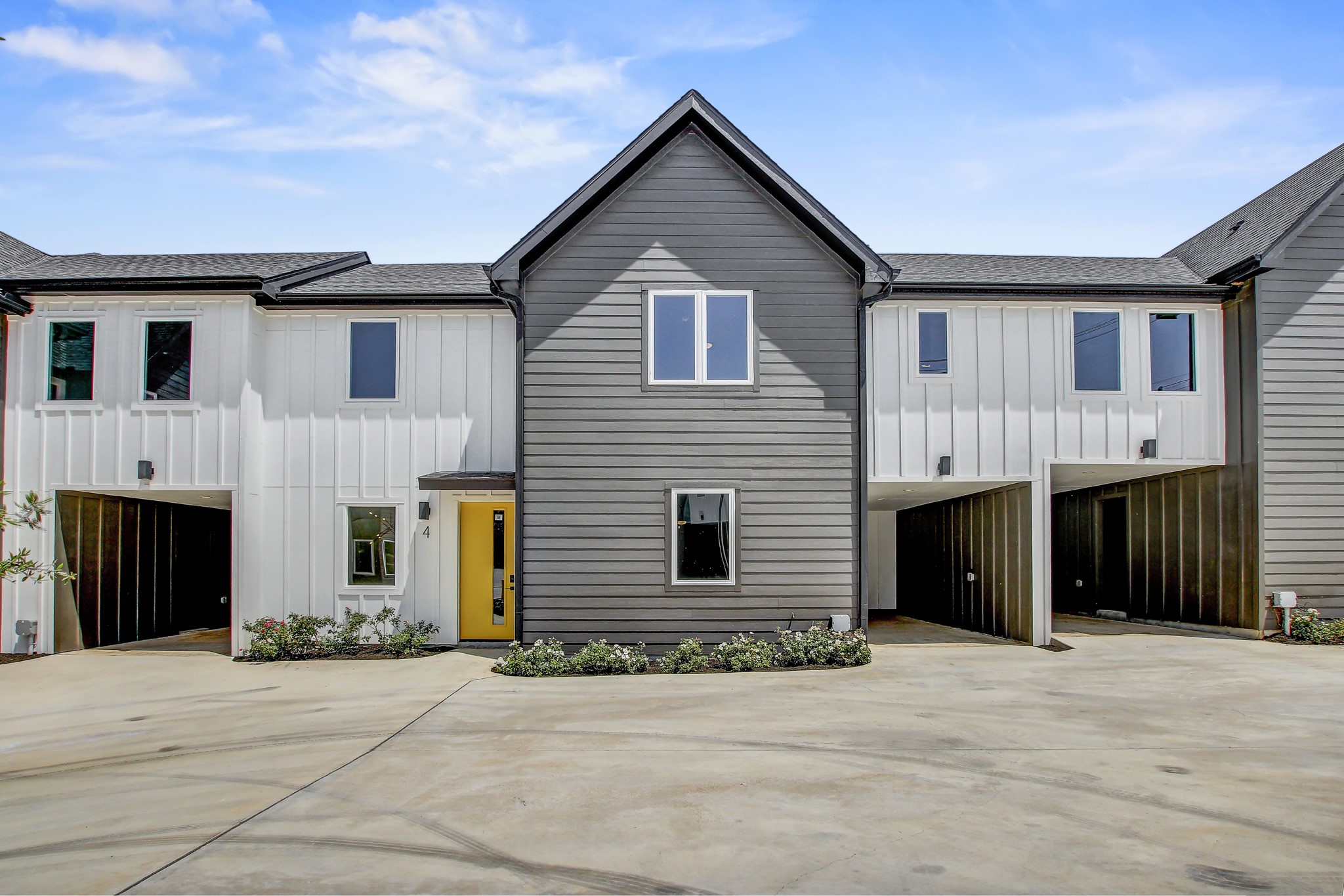 4127 East 12th Street, Unit 4 Austin, TX 78721 - Photo 27 of 32 View of front of home with board and batten siding, concrete driveway, and a shingled roof