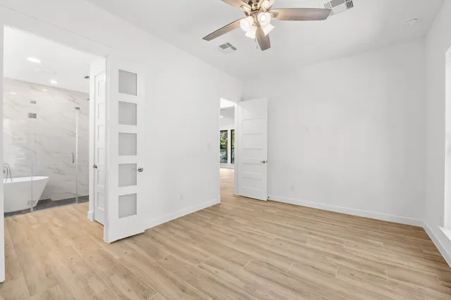 wooden floor in an empty room with a bathroom
