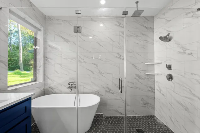 a white bath tub sitting next to a white shower
