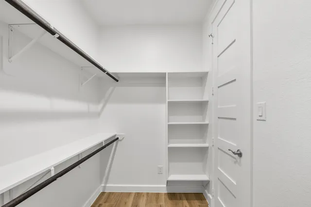 a view of walk in closet with empty racks