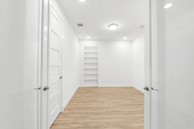 a view of a hallway with a wooden shelves