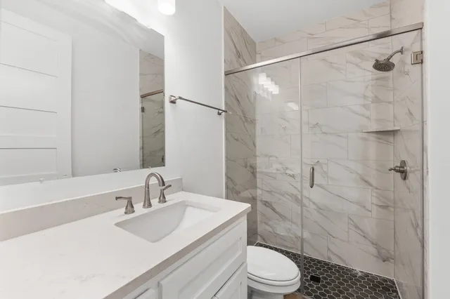 a bathroom with a sink toilet and shower