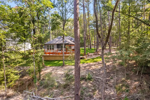 a view of a house with large trees and a yard