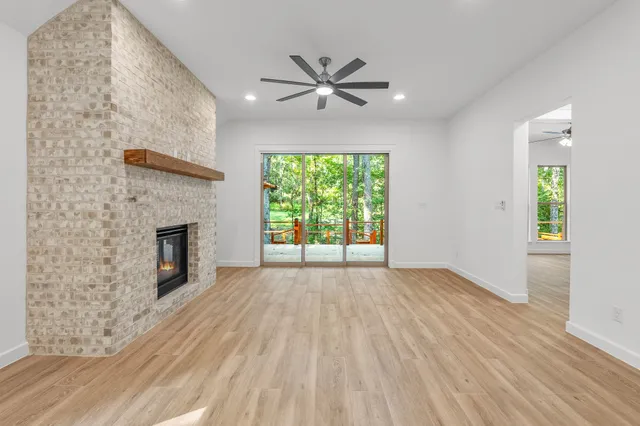 a view of empty room with wooden floor and fireplace