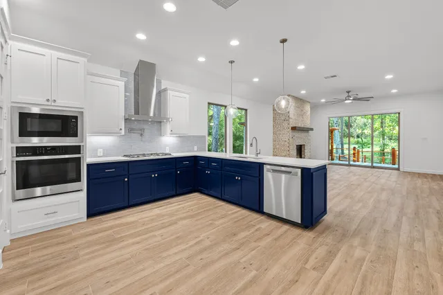a kitchen with stainless steel appliances kitchen island granite countertop a stove a sink and a microwave