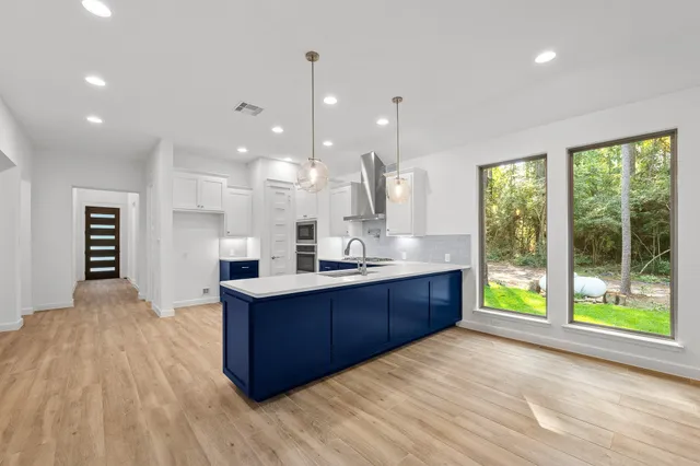 a large kitchen with kitchen island a large island in the center and a large window