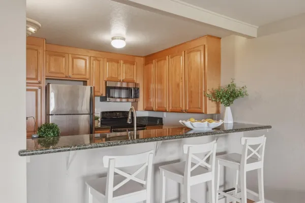 a kitchen with granite countertop a sink stainless steel appliances and cabinets