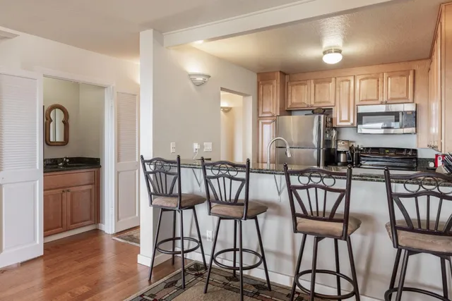 a kitchen with stainless steel appliances granite countertop a sink and a refrigerator