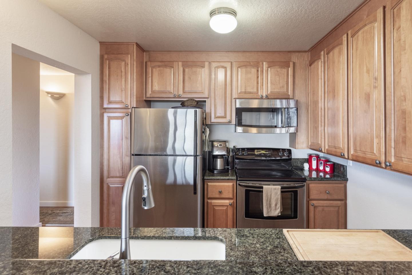22 Ocean Pines Lane, Unit 22 Pebble Beach, CA 93953 - Photo 12 of 28 a kitchen with stainless steel appliances granite countertop a refrigerator and a stove