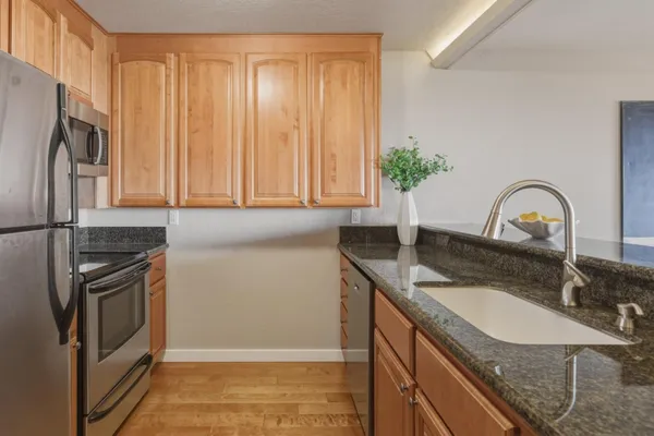 a bathroom with a granite countertop toilet sink and mirror