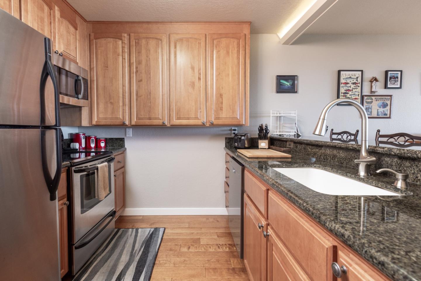 22 Ocean Pines Lane, Unit 22 Pebble Beach, CA 93953 - Photo 13 of 28 a kitchen with stainless steel appliances granite countertop a sink and a refrigerator