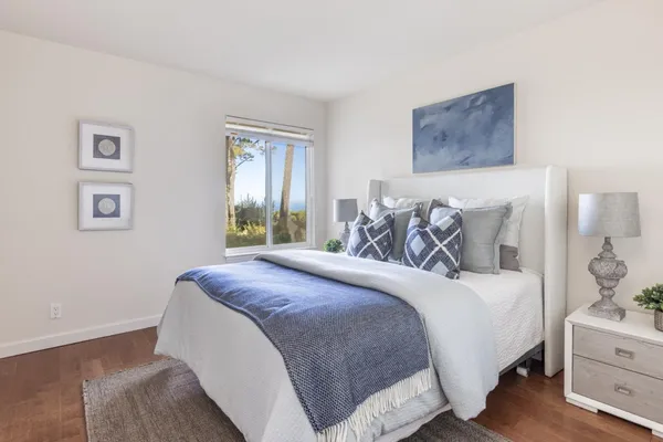a bedroom with a large bed and wooden floor