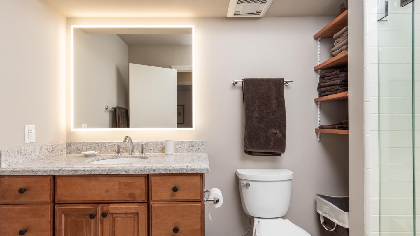 22 Ocean Pines Lane, Unit 22 Pebble Beach, CA 93953 - Photo 15 of 28 a bathroom with a granite countertop sink toilet and mirror