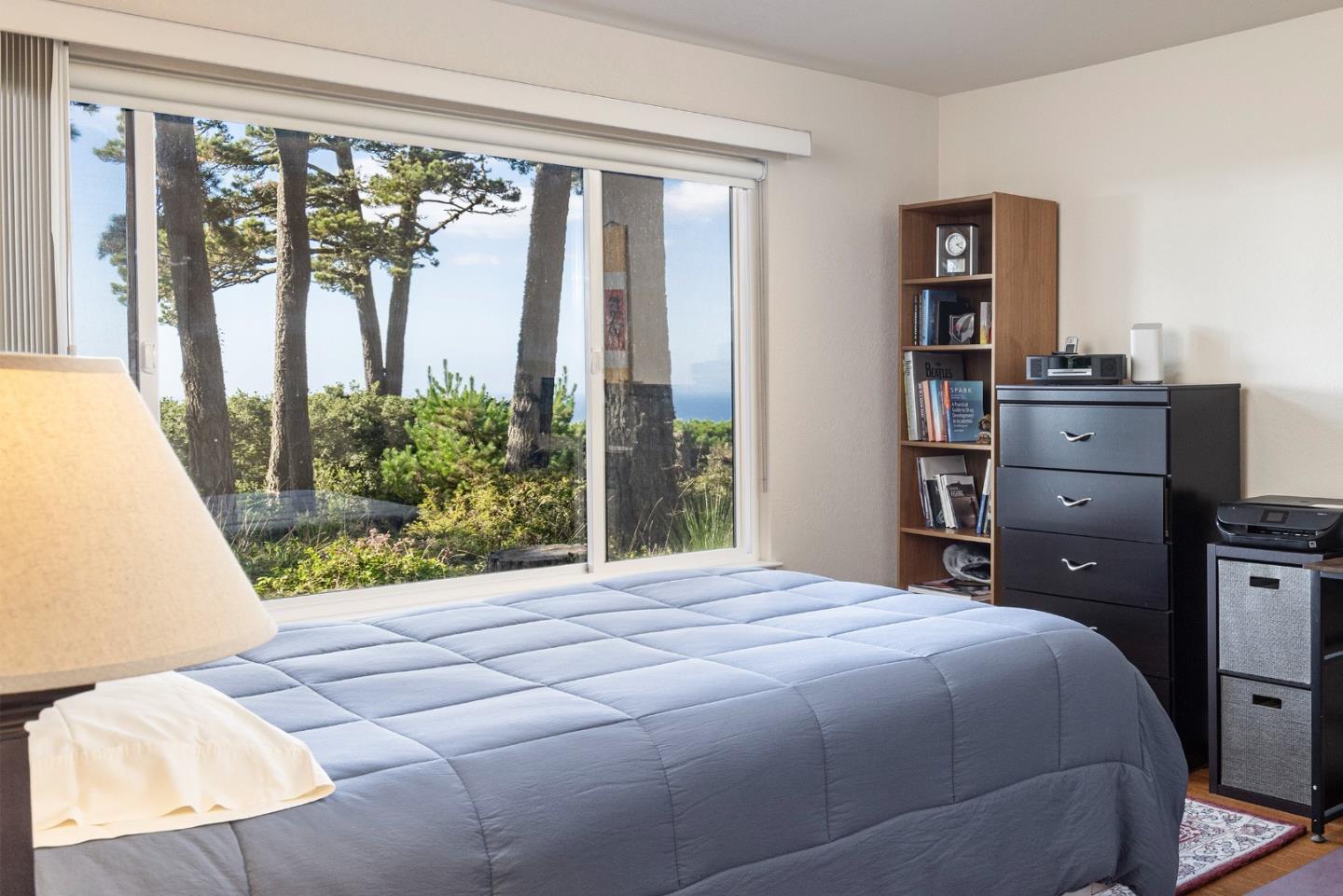 22 Ocean Pines Lane, Unit 22 Pebble Beach, CA 93953 - Photo 16 of 28 a bedroom with a bed and large window