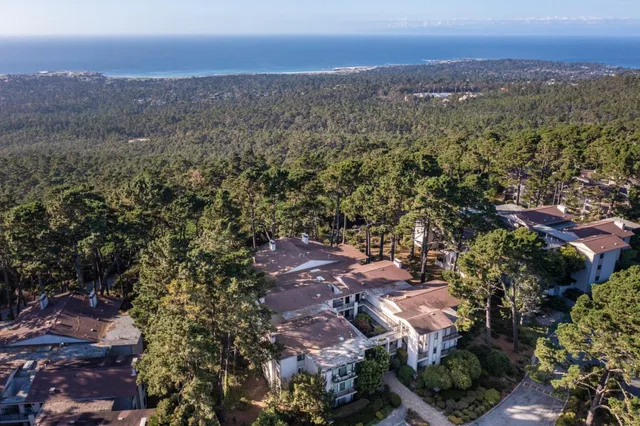 an aerial view of house with yard and mountain view in back