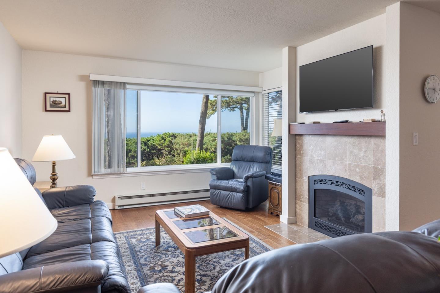 22 Ocean Pines Lane, Unit 22 Pebble Beach, CA 93953 - Photo 5 of 28 a living room with furniture a flat screen tv and a fireplace