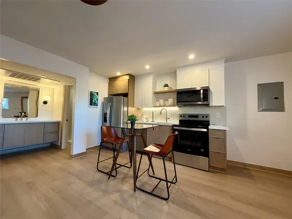 a kitchen with stainless steel appliances kitchen island granite countertop a refrigerator and a stove top oven
