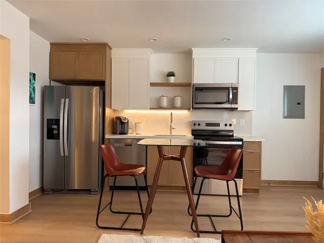 a kitchen with stainless steel appliances a refrigerator and a stove top oven