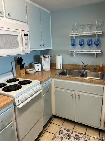 a kitchen with granite countertop a refrigerator and a stove top oven
