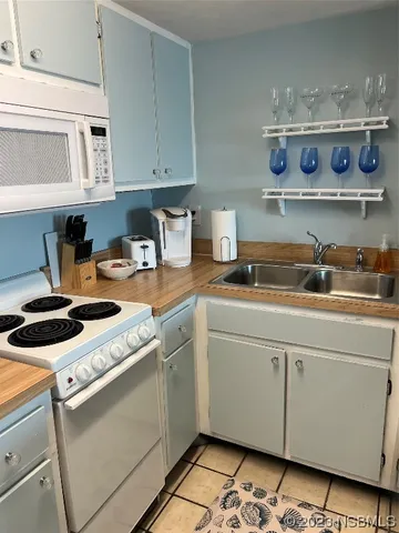 a kitchen with granite countertop a refrigerator and a stove top oven