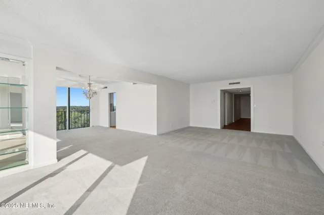 a living room with furniture a chandelier and a dining table