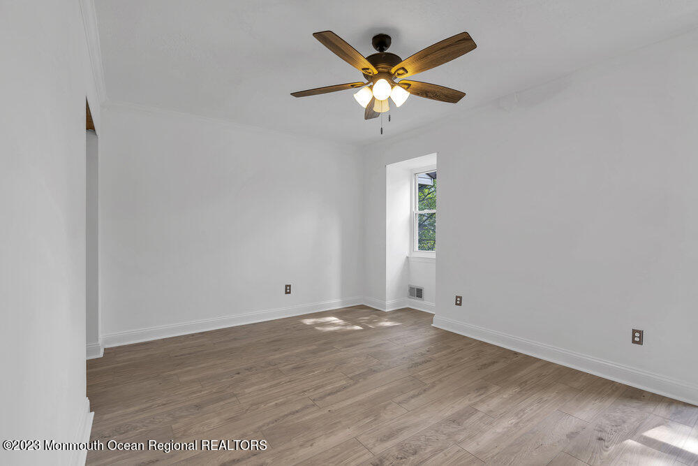 570 Labanna Court Brick, NJ 08724 - Photo 13 of 28 an empty room with a chandelier fan and windows