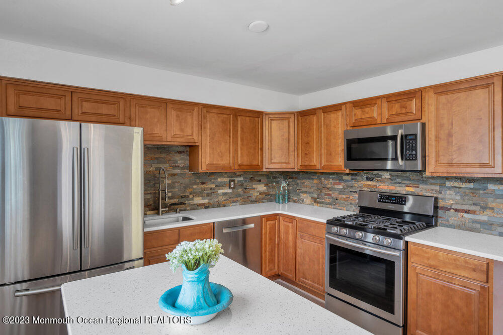 570 Labanna Court Brick, NJ 08724 - Photo 10 of 28 a kitchen with stainless steel appliances a stove a sink and a microwave