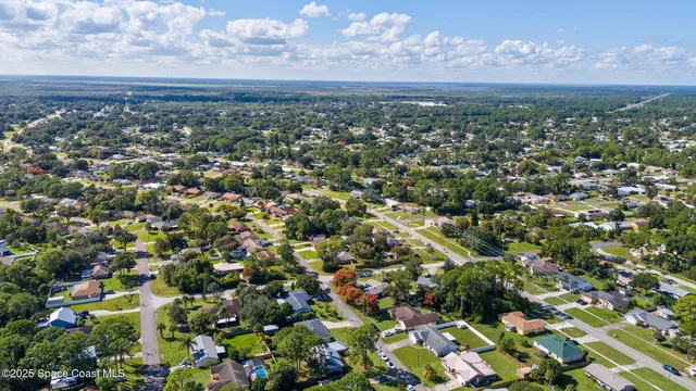 an aerial view of residential houses with outdoor space and trees