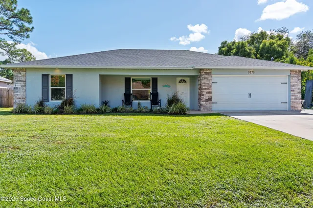 a view of a house with backyard and garden