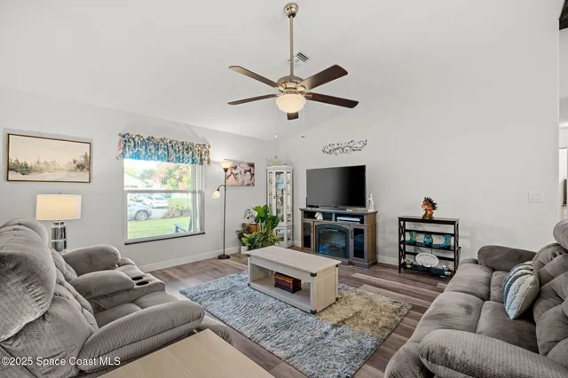 a living room with furniture a flat screen tv and a dining table