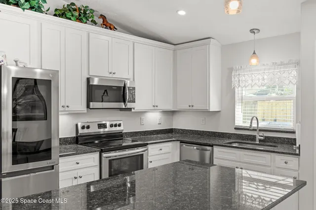 a kitchen with granite countertop sink stove and dining table
