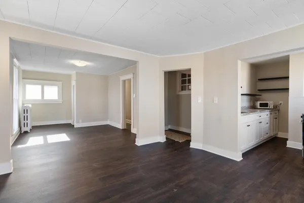 an empty room with wooden floor and a window