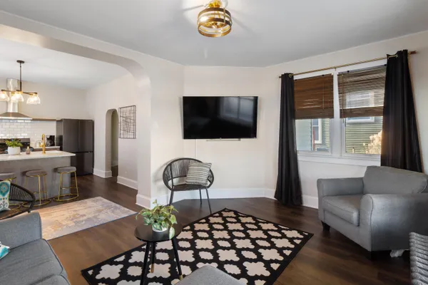 a kitchen with stainless steel appliances a dining table chairs a refrigerator and cabinets