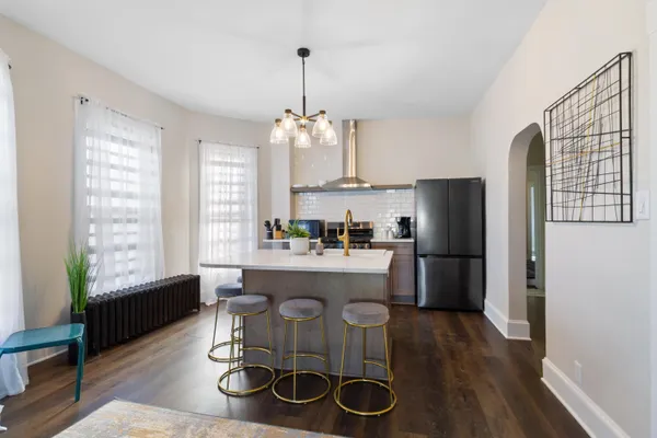 a kitchen with refrigerator a stove and wooden floor