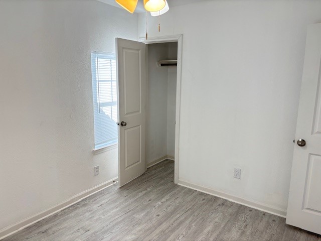 5217 Malmedy Road, Unit A Houston, TX 77033 - Photo 12 of 22 an empty room with wooden floor and windows