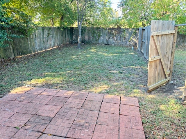 5217 Malmedy Road, Unit A Houston, TX 77033 - Photo 20 of 22 a view of a backyard with large trees and wooden fence