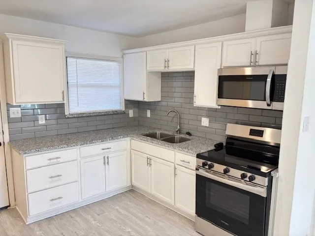 a kitchen with cabinets stainless steel appliances and a sink