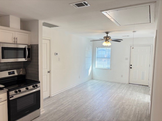 5217 Malmedy Road, Unit A Houston, TX 77033 - Photo 5 of 22 a view of a kitchen with an empty space wooden floor and a kitchen